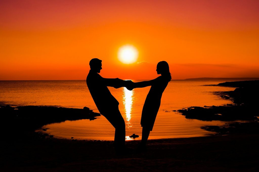 Couple on the beach at sunset - How to Date a Woman who Travels