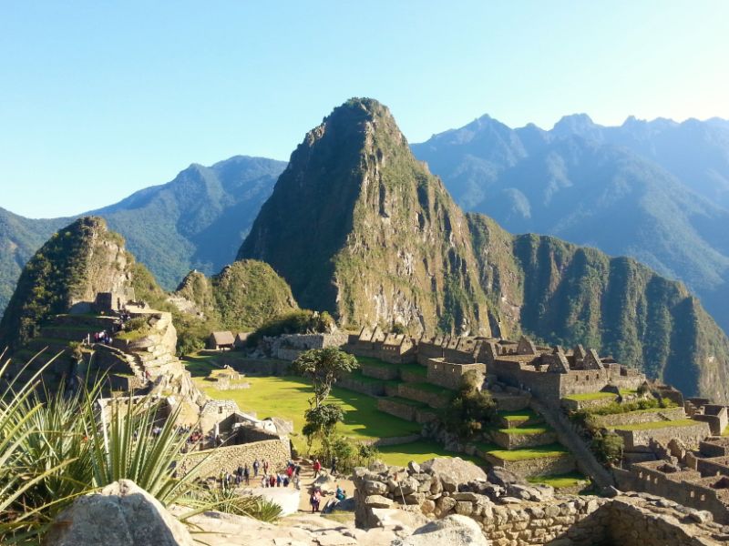 Machu Picchu Inca ruins bathed in sunshine with Huayna Picchu Mountin in the background 