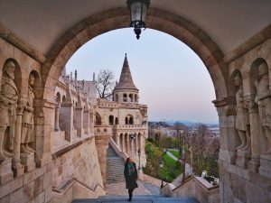 Fishermen's Bastion at Sunrise - Claire Walking Through an Archway with a tower in the background- Budapest on a Budget