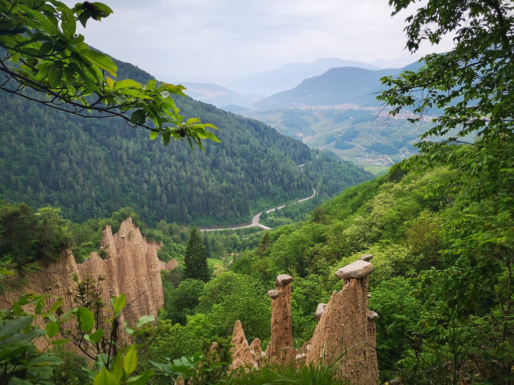 The Pyramids of Segonzano in Trentino stone formations with a beautiful alpine view in the background - Reasons to Visit Trentino