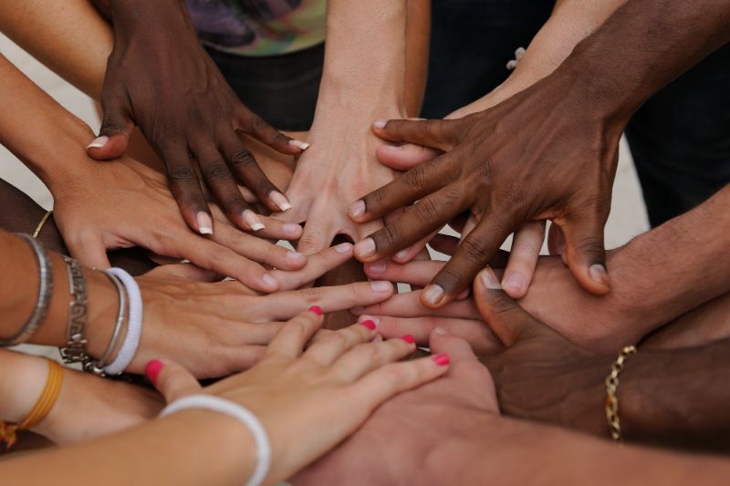 Hands coming together in the middle of a circle, in a collaborative gesture - Get a Worldpackers Discount Code for Collaborative Experiences Around the World