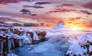 Iceland in Winter - Mount Kirkjufell covered in Snow with the sunrise behind