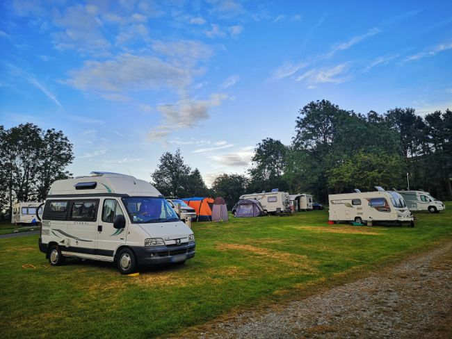 Mabel the Motorhome parked on grass with other caravans and campervans around her - Even if Campsites are Busy, Campers are Usually Really Friendly