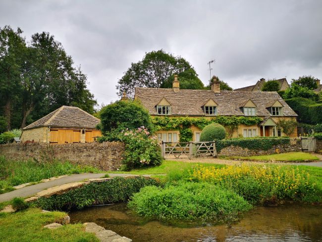 The Cotswolds in England - One of My Local Travel Experiences - A Pretty Cottage with a stream and bridge in front