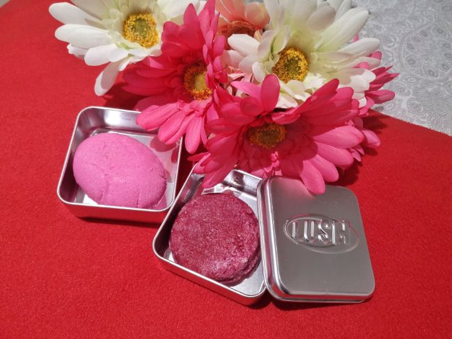 Pink Lush Shampoo and Conditioner Bars on a red table with pink flowers