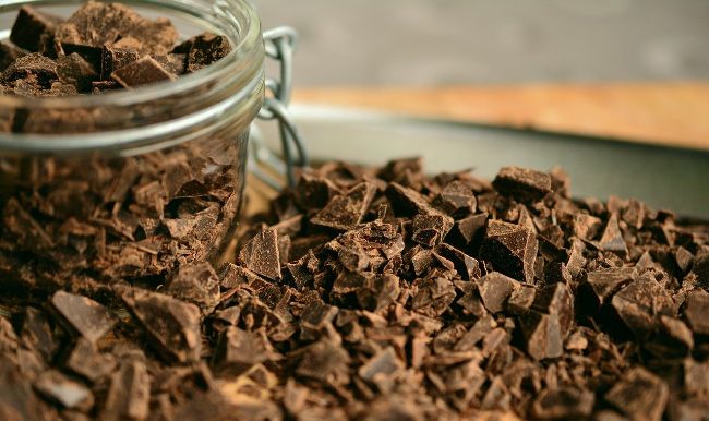 Taste some Delicious Chocolate - Chocolate chunks in a glass jar spilling onto the table
