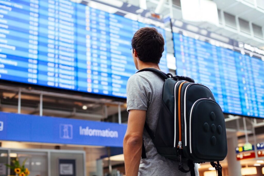Man in Airport with a Backpack on his Back - The Best Carry On Travel Backpacks