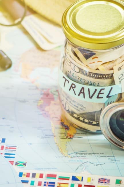 Travel Savings Jar on a Map of the World - Volunteering Abroad for Free