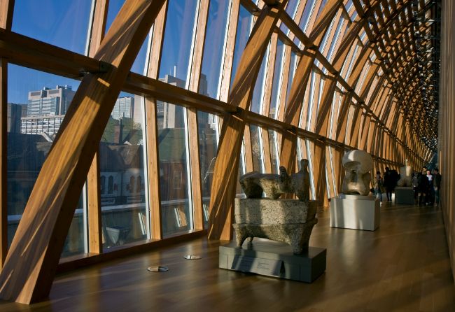 Inside the Art Gallery of Ontario Toronto with wooden beams leading from the floor to the ceiling with large windows on the left hand side