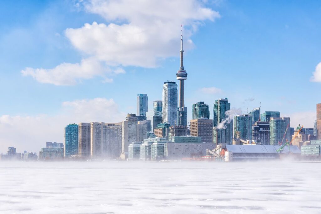 The Best Things to do in Toronto in Winter - Frozen Lake Ontario with the Toronto Skyline beyond