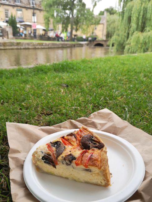 Piece of Quick on a picnic plate on grass next to the River - A Picnic next to the River is an Essential Activity in Bourton on the Water