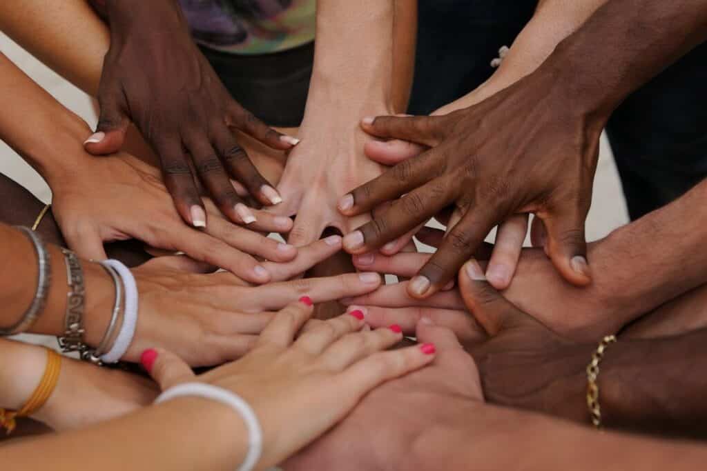 Código Promocional Worldpackers - manos de colores diferentes juntos en un grupo