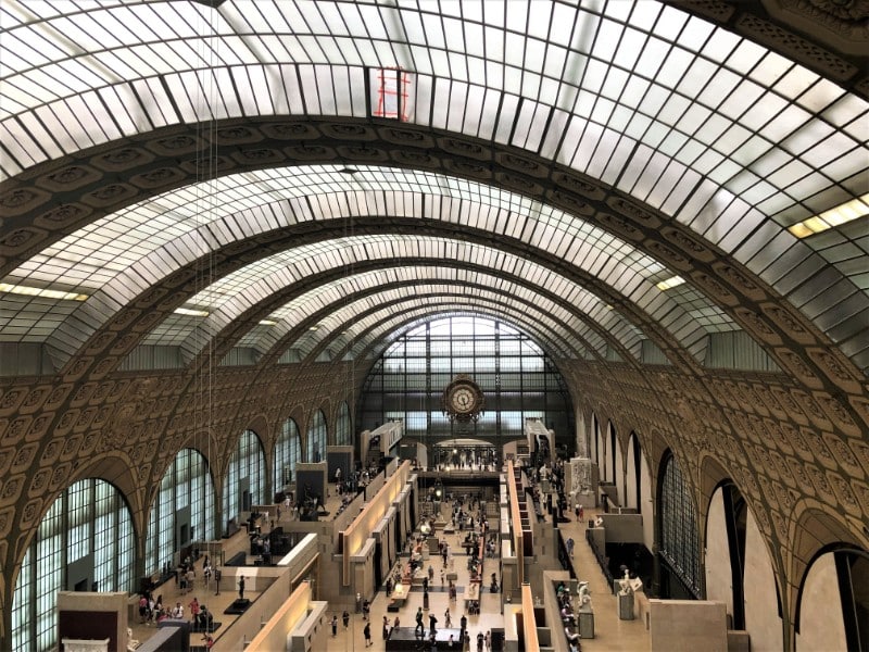 Inside Musee d'Orsay - an old station building with curved roof and a clock at the far end of the large hall - Explore the Museums in Paris in Winter