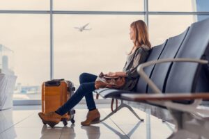 Woman Sitting Alone at the Airport - Tips for Flying Alone for the First Time