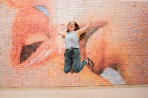 Claire Jumping at the Kiss Mural in Barcelona Spain - How to Prepare for Travelling Alone for the First Time